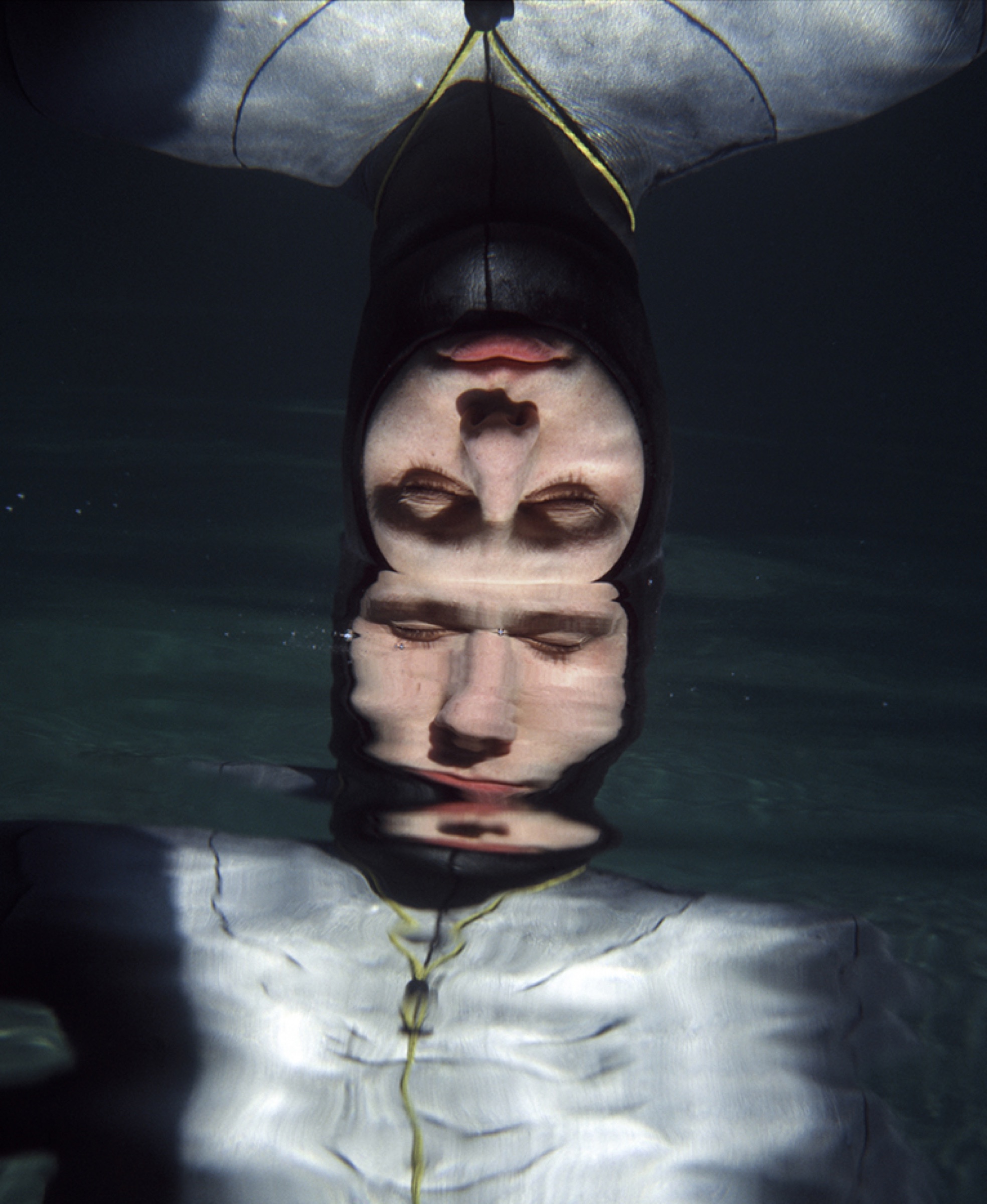 Three freedivers in a red-walled room — each inside their own preparation