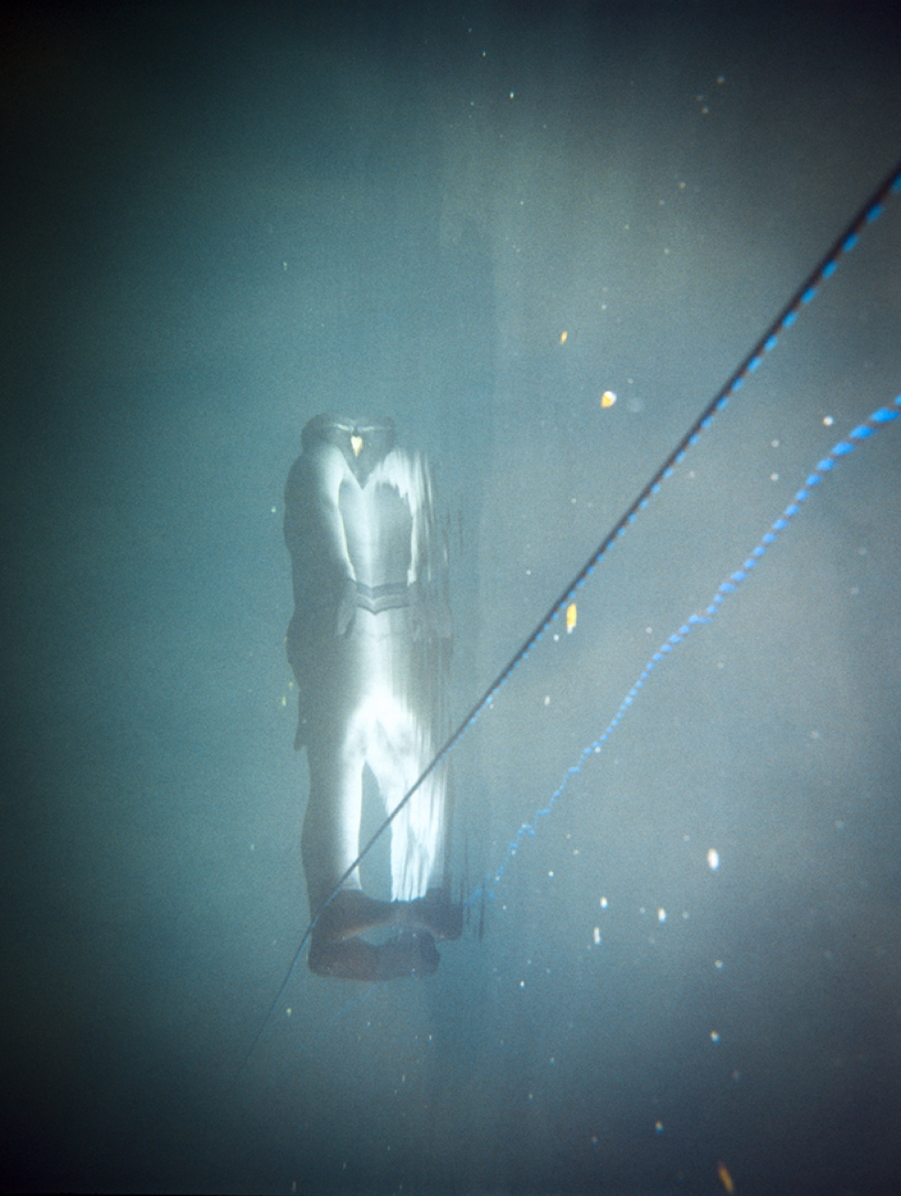 A lone diver in a mountain lake — crushed by scale, held by silence
