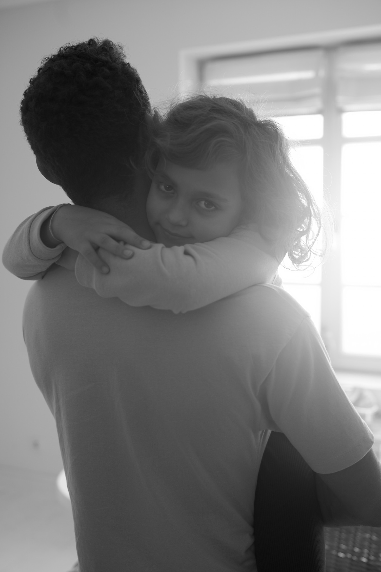 Daughter hugging her father, looking over his shoulder — trust made visible