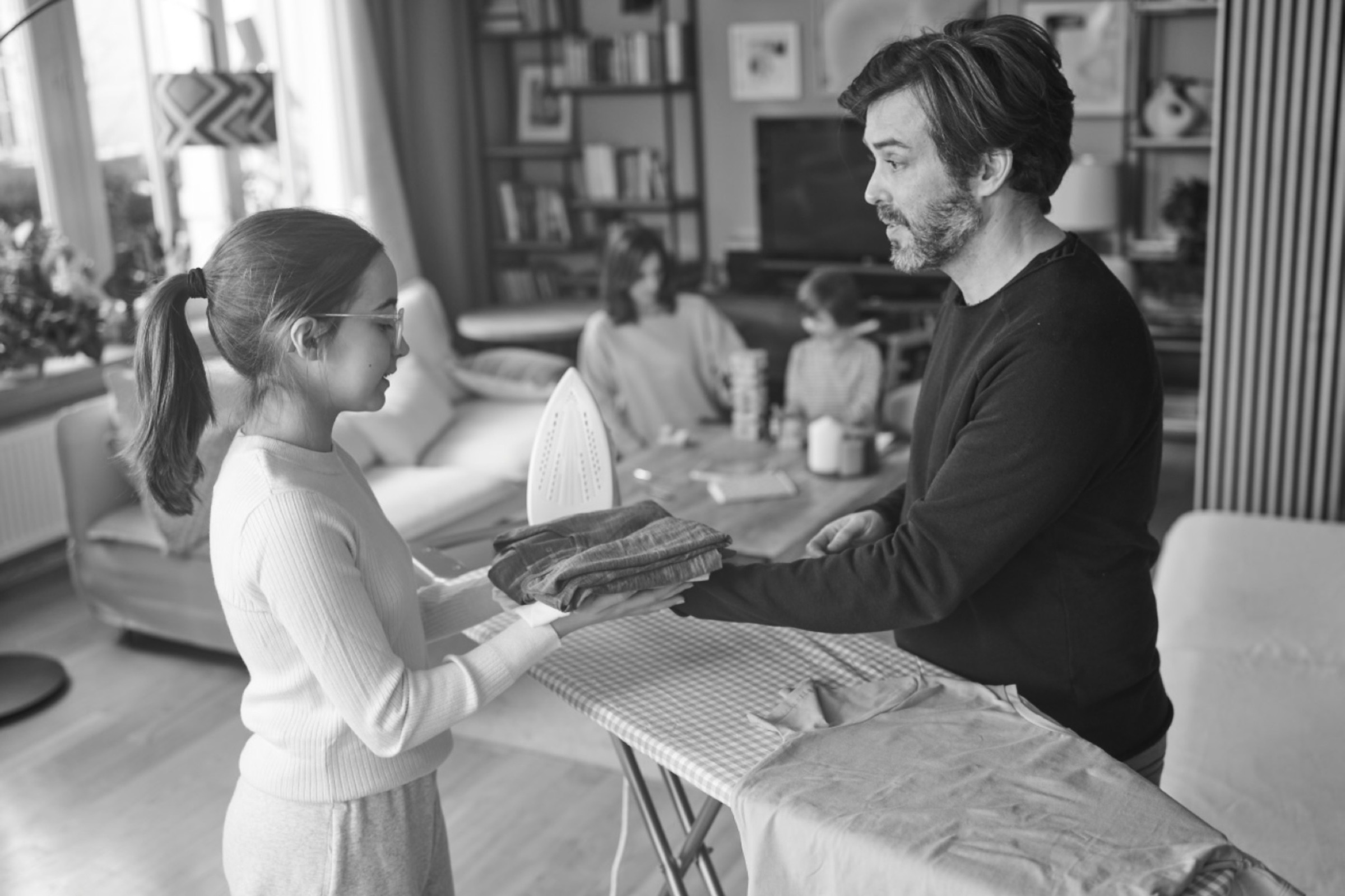 Father and daughter sharing an everyday domestic ritual — natural, unposed