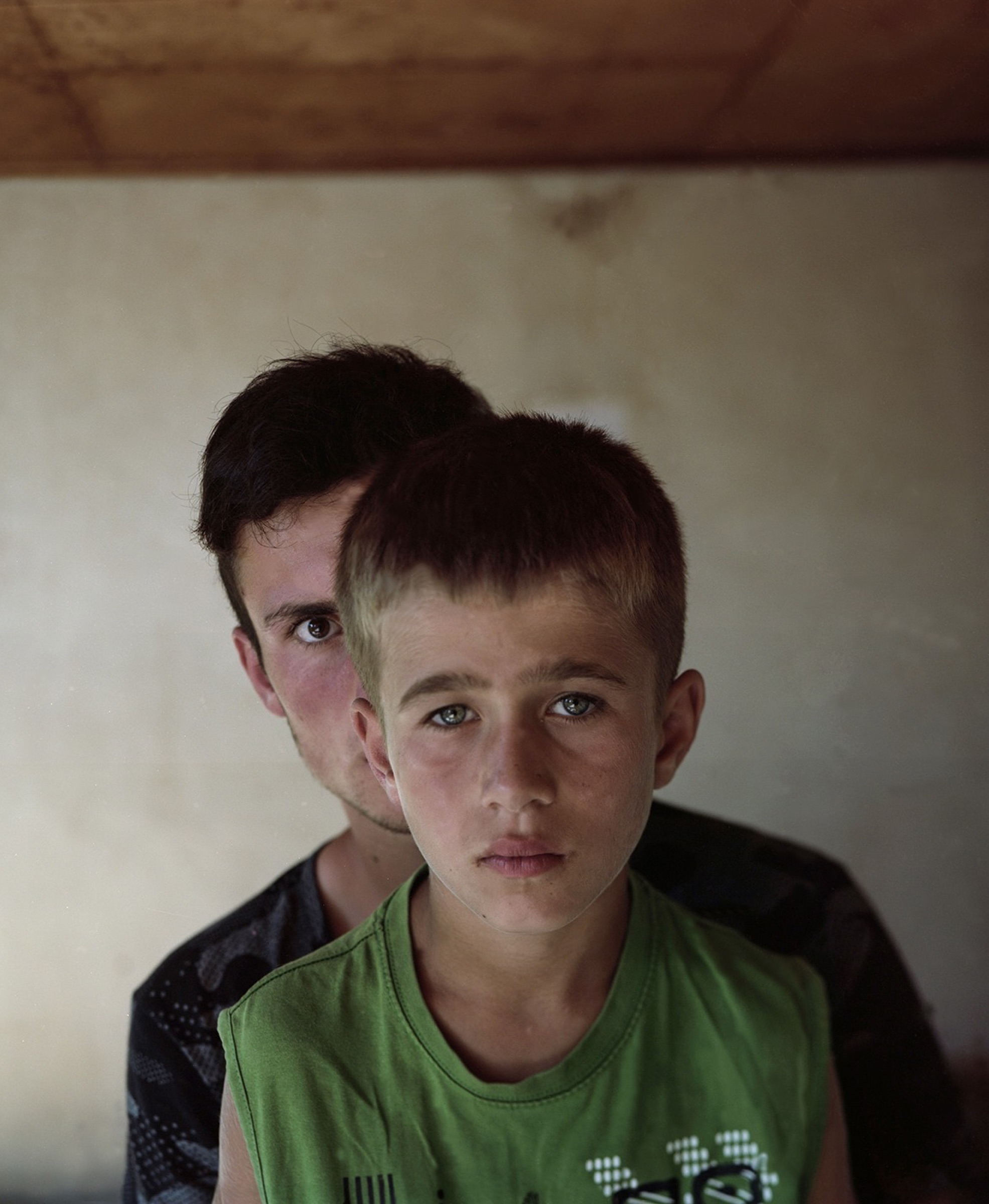 Two boys facing the camera — an older boy behind a younger one, Pankisi Valley