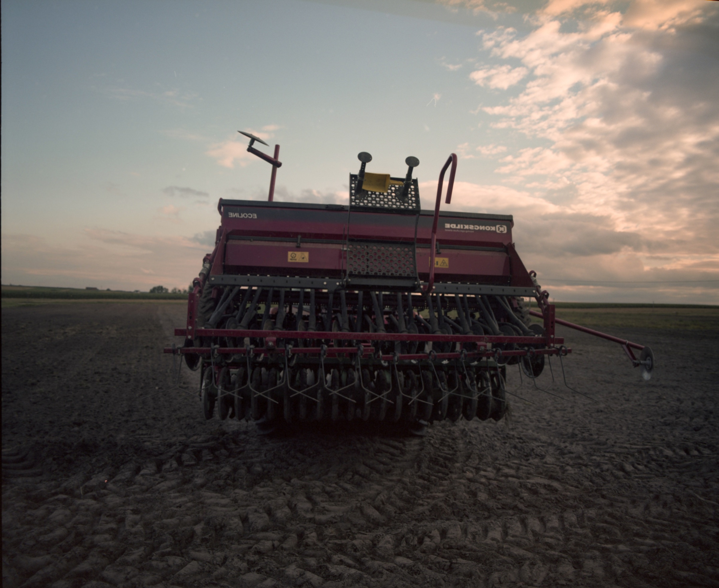 Agricultural seeder machine in a dark field at dusk — Podlasie