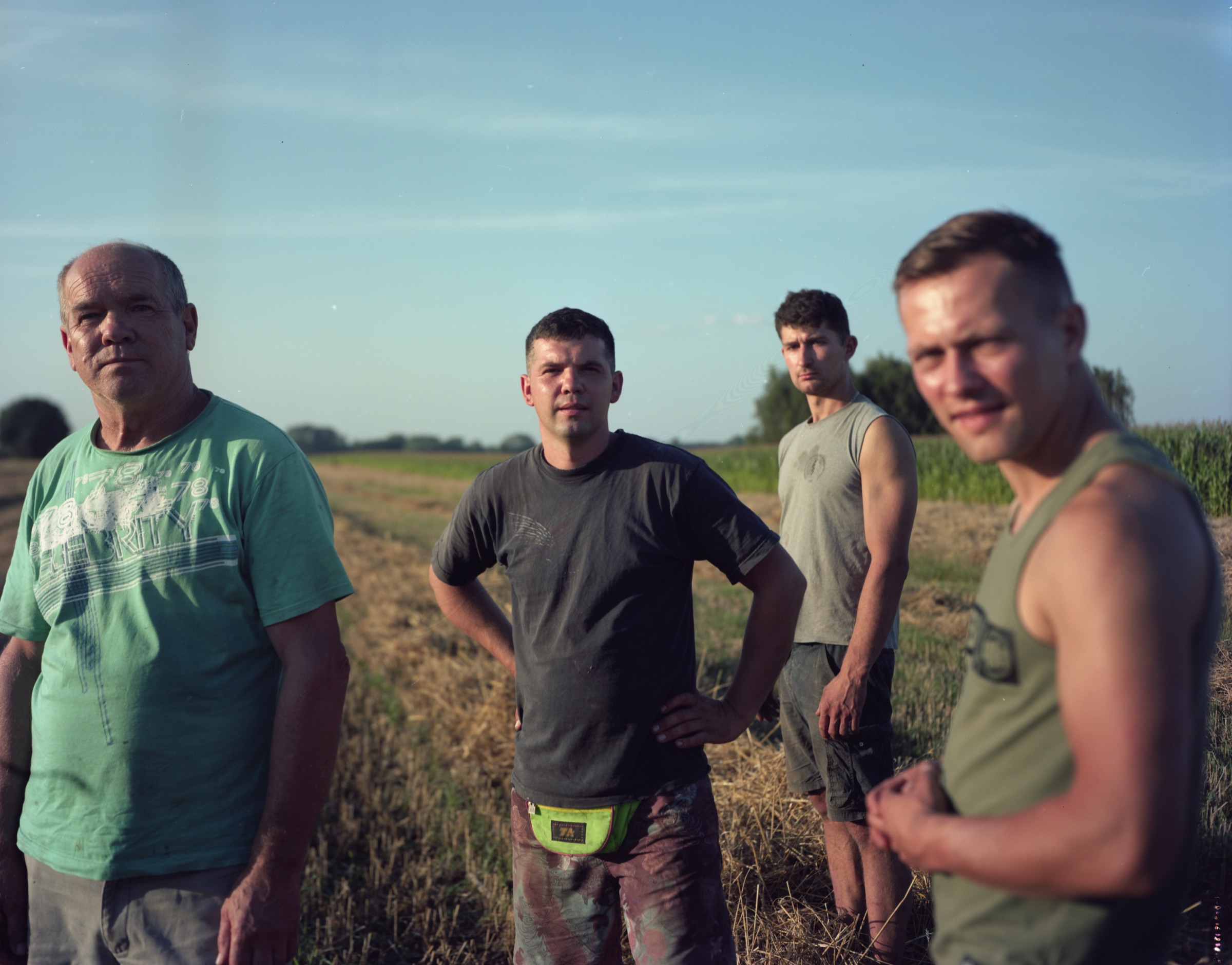 Four men in a field at golden hour, looking at camera — Podlasie